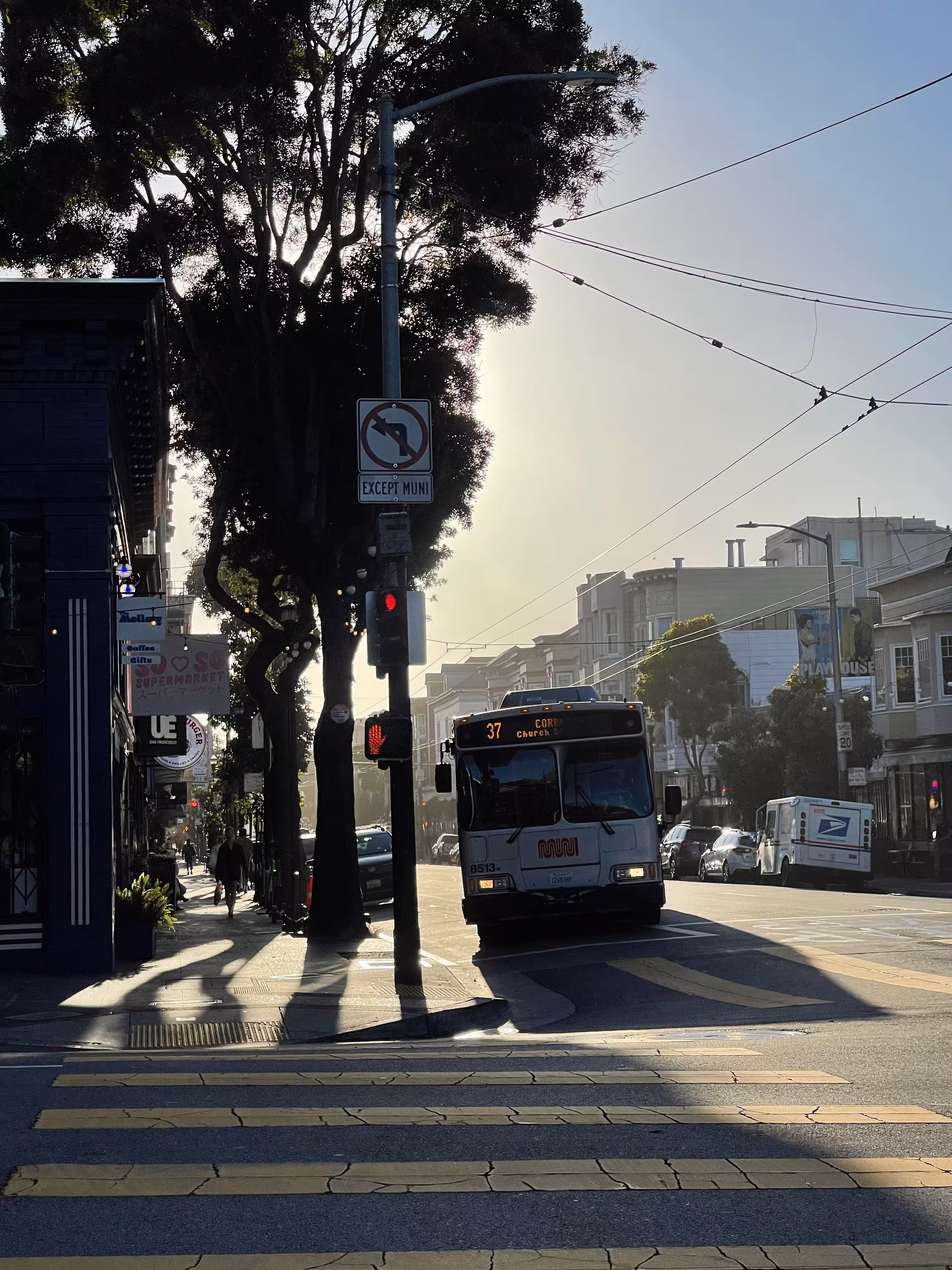 A backlit Muni bus at the intersection of Haight and Masonic.